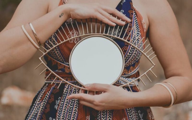 femme tenant un miroir en forme d'oeil